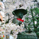 A large bronze statue of Kasa-Jizō, Jizō bodhisattva (Jizō-bosatsu ) with a conical hat, at the entrance of Taisō-ji temple.